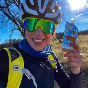 Charlotte Olsen holding Vespa Jr Pack wearing cycling gear